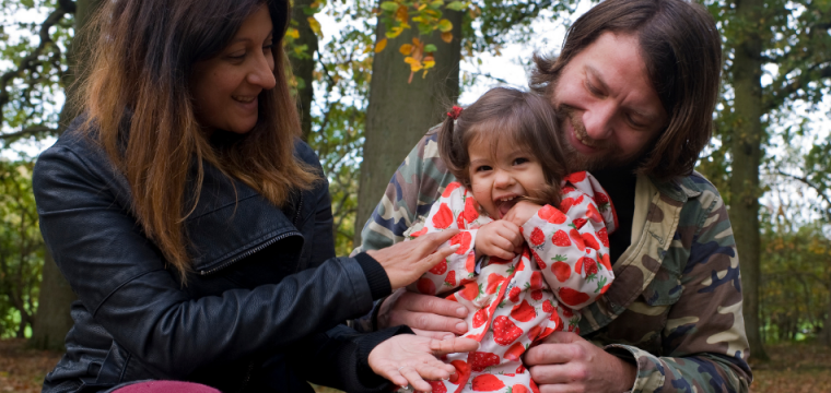 Adoption Focus image of a little girl and her parents in the woods