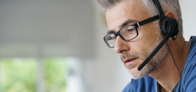 Image of a man wearing a headset, manning an advice line for Money Advice Trust 